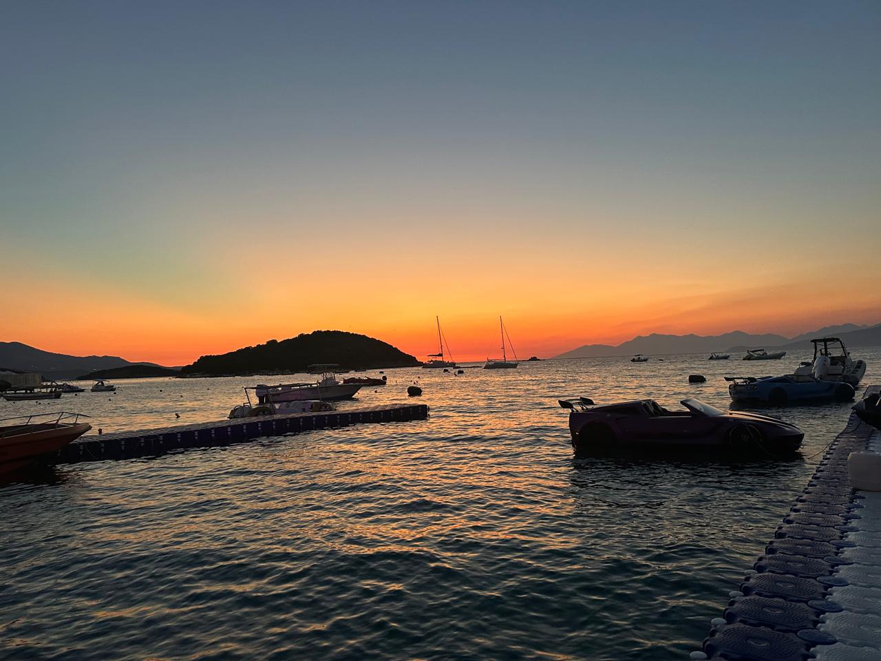 Sunset over Ksamil with boats and jet cars